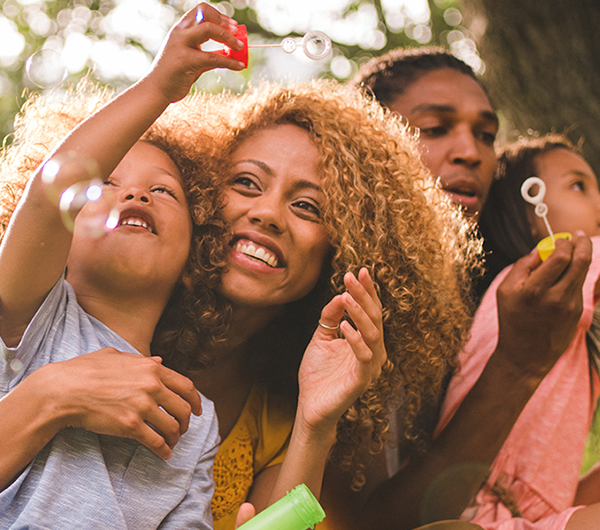 family of four blowing bubbles