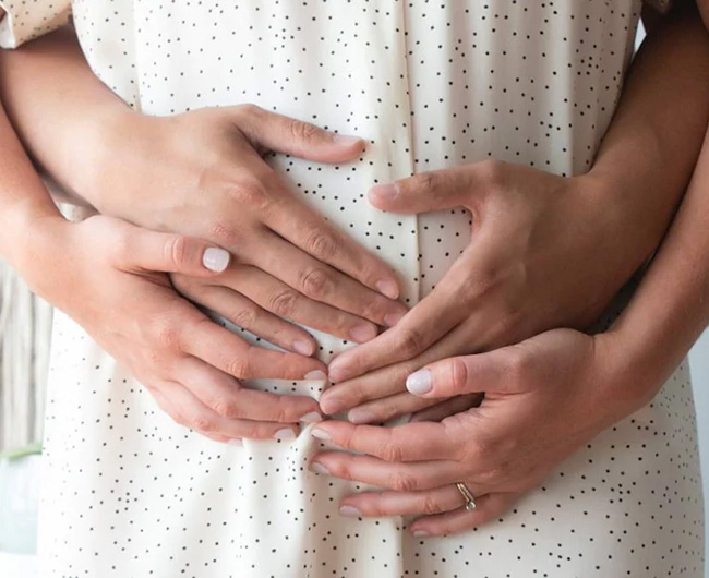 Hands over pregnant woman's stomach