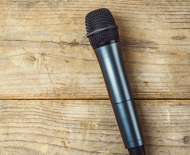 Microphone on a wooden office desk background. View from above.